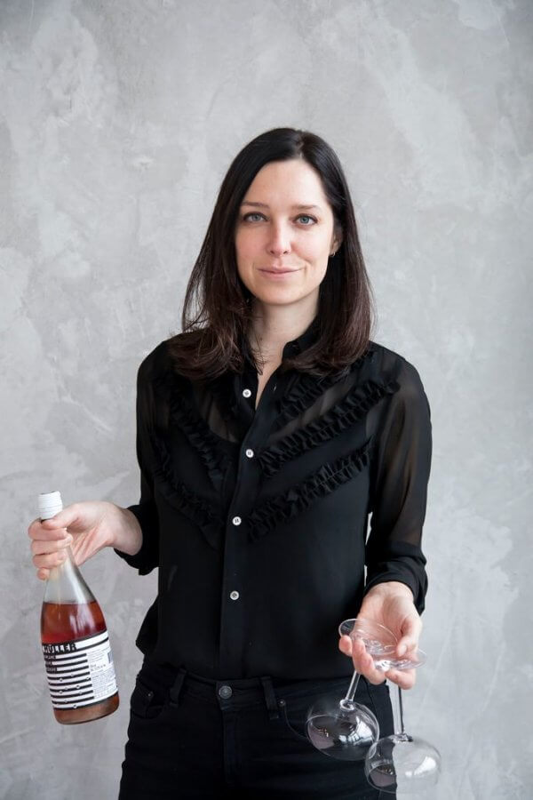 Julia holding wine and wine glasses. 