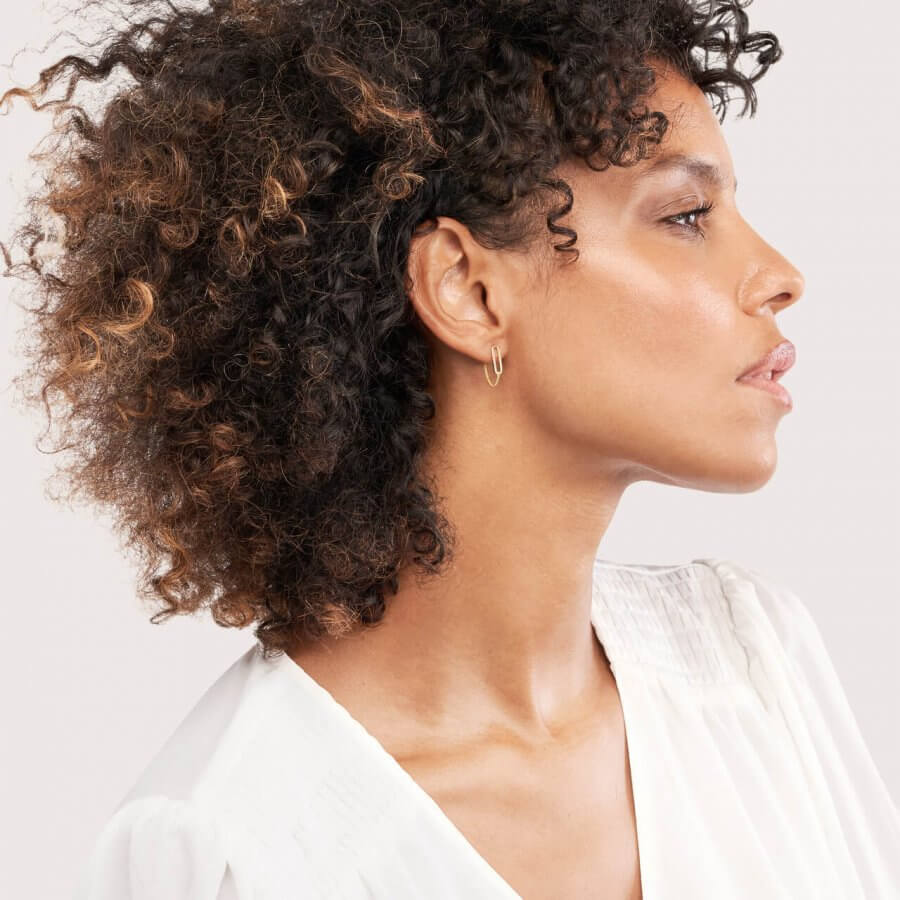 Profile of a Southern woman with curly hair and a white blouse, looking to her left with a neutral expression.