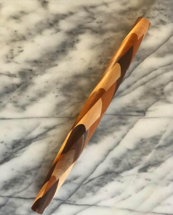 A twisted wooden stick resting on a marble surface, featuring alternating light and dark wood patterns, is one of the Southern FINDS for May.