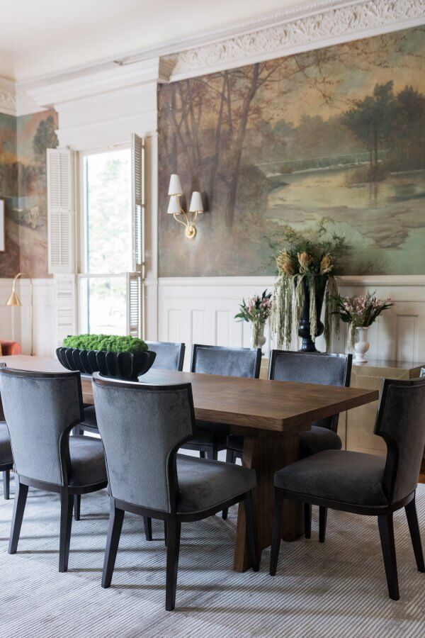 Dining room table and chairs in front of a wall featuring a landscape mural