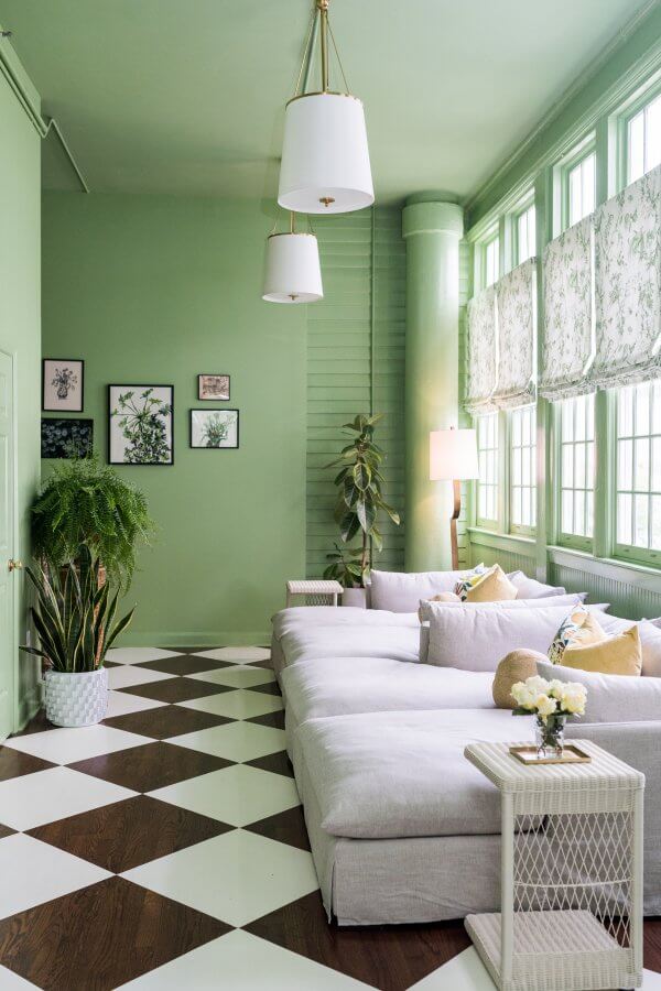 Sunroom with green walls, white couches, and a checkered floor