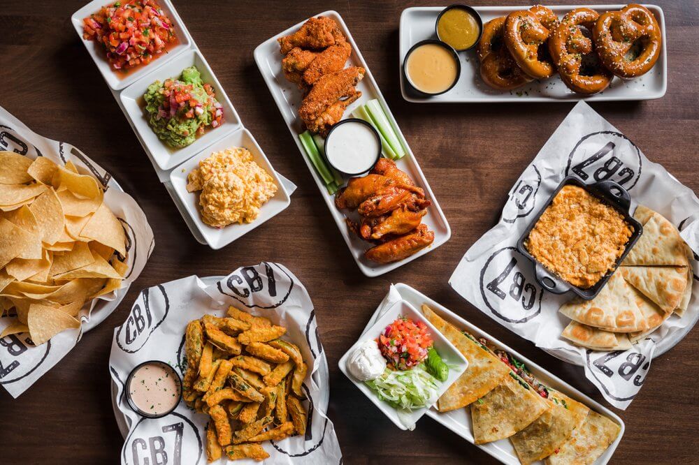 Selection of bar food including wings, dips, quesadillas and pretzels