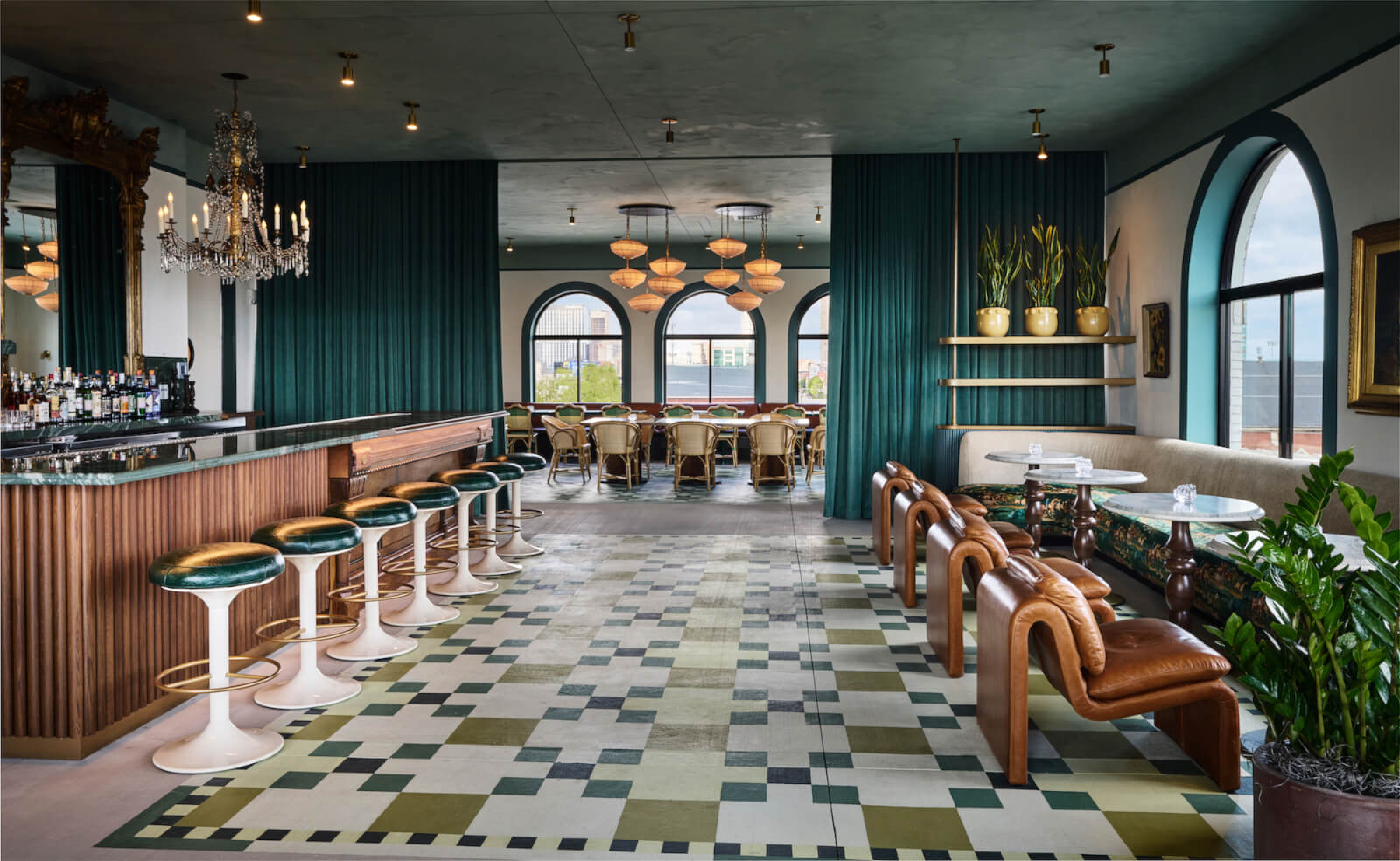 Hotel bar with green curtains and patterned tile floors.