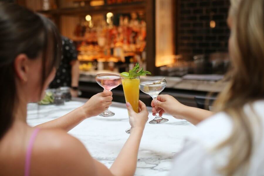 Three craft cocktails toasting at Stateside Kitchen