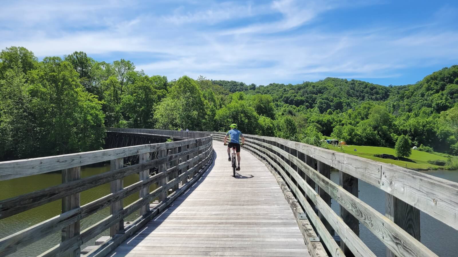 lone biker on wooden bike trail on sunny day