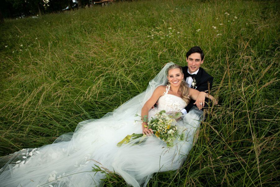 A Wild Storybook Wedding You Won't Believe - 2 Bride and groom sit in a field of tall grass