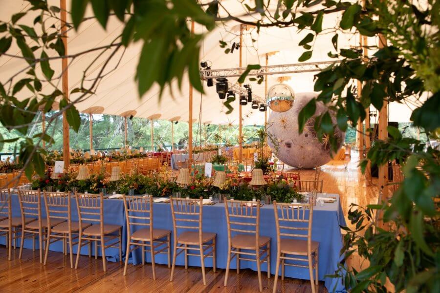 A Wild Storybook Wedding You Won't Believe - 19 Seated wedding dinner under a tent with giant moon and blue tablecloths