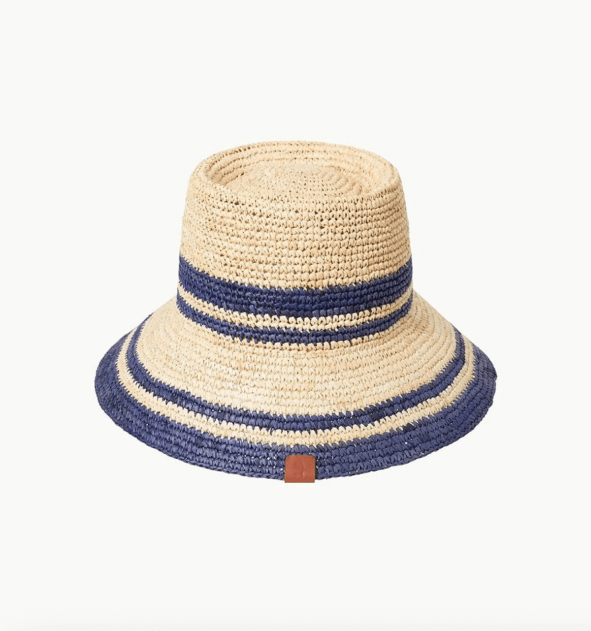 Straw-like hat boasts a wide brim adorned with two horizontal dark blue stripes.
