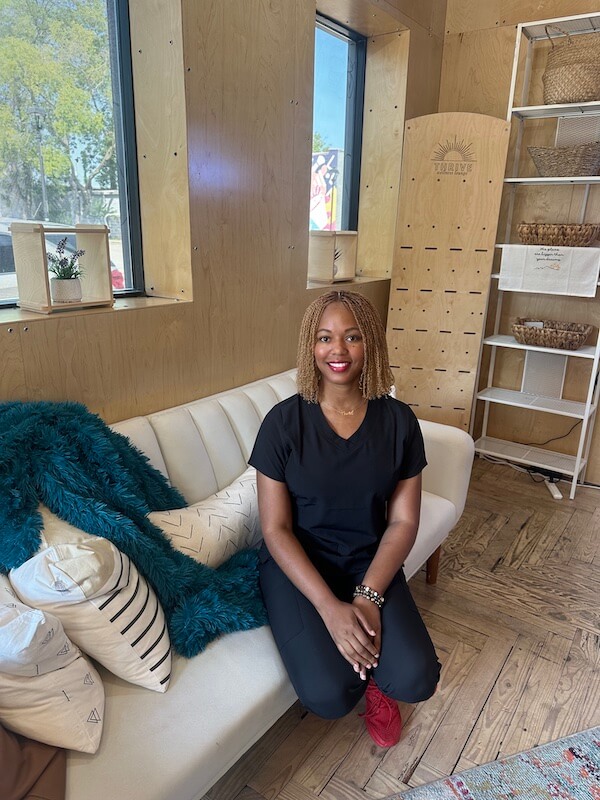 Tish Fletcher seated on sofa in shop.