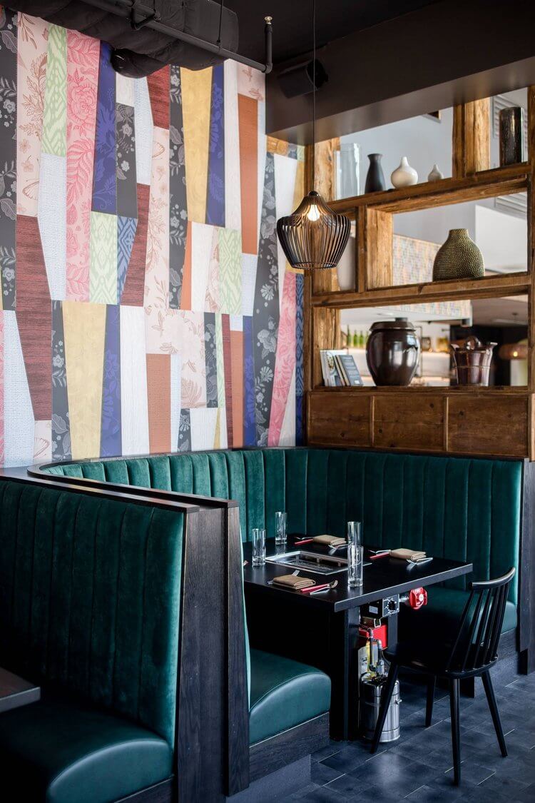 Colorful restaurant interior with green velvet booths.