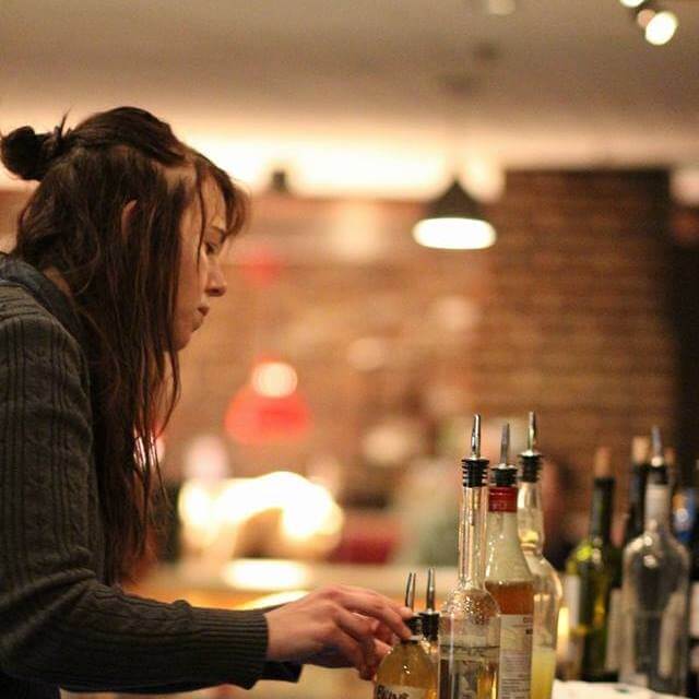 Brunette woman bartending.