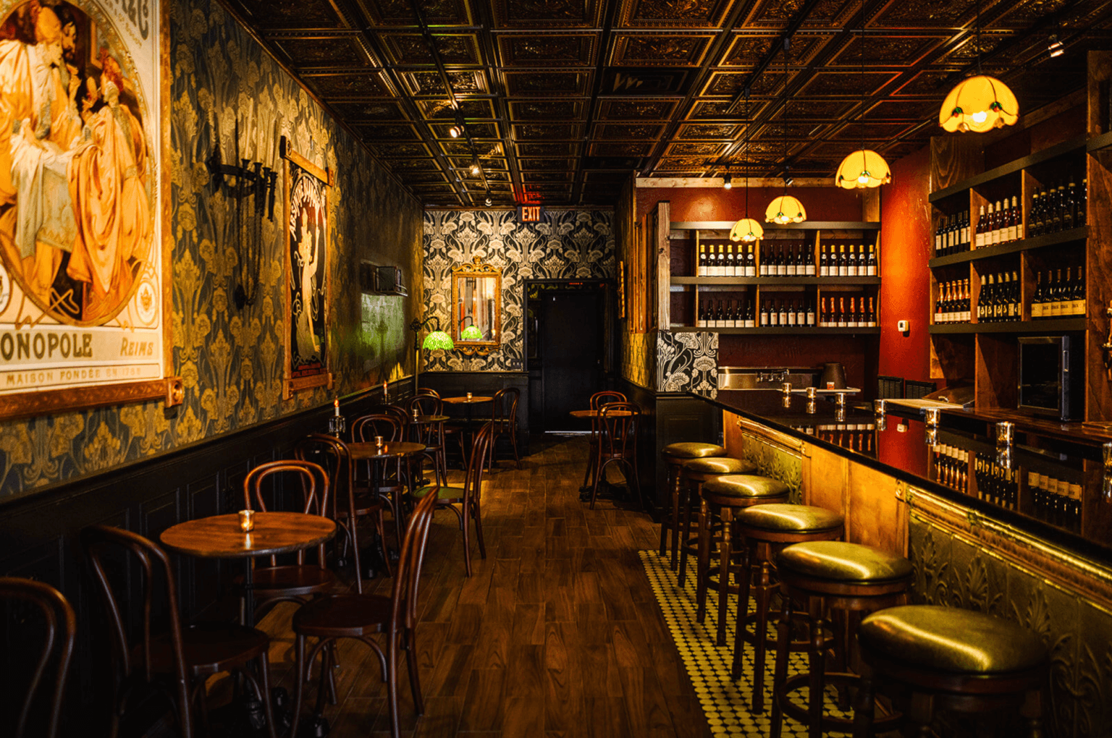 Nashville wine bar with green patterned wallpaper and wood accents.