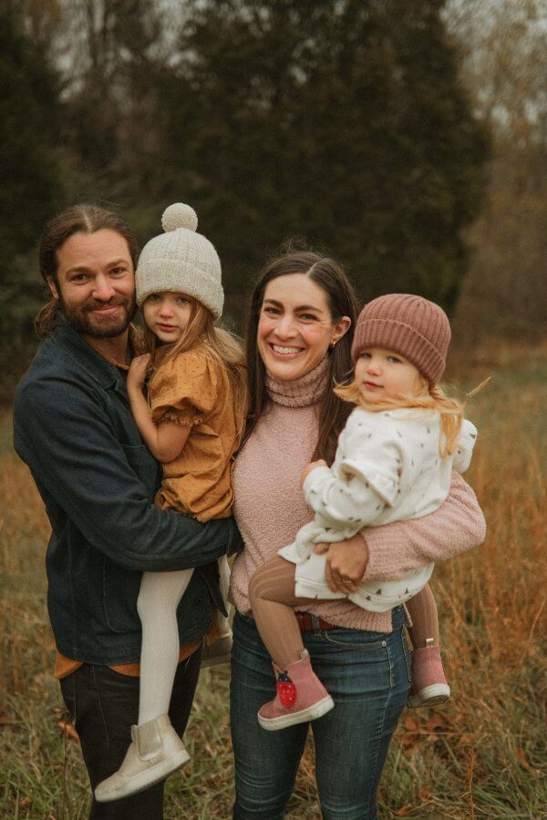 Man, woman, and two young girls in a field