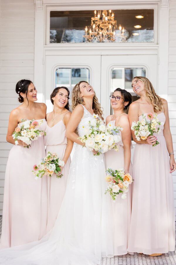 Bridesmaids and bride laughing