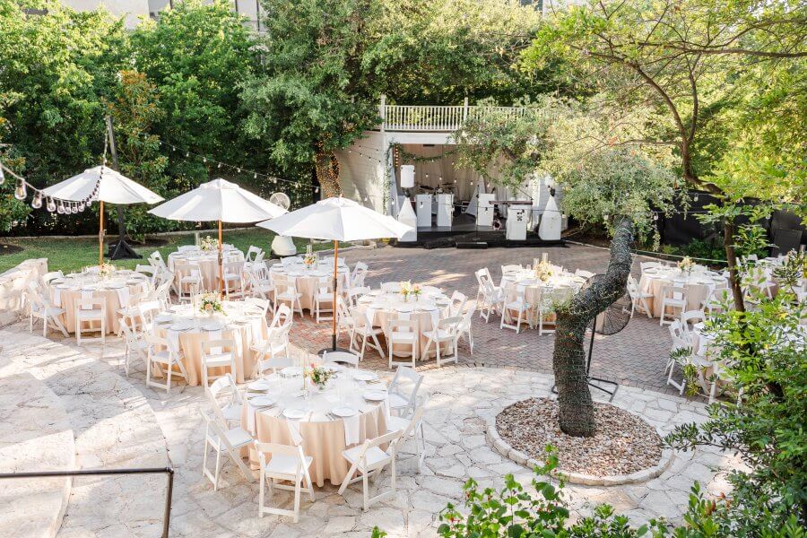 Beautiful tables outside on a terrace with a tree and umbrellas