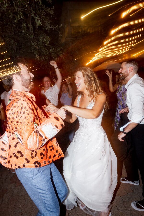 Groom in orange tiger jacket dancing with bride at night