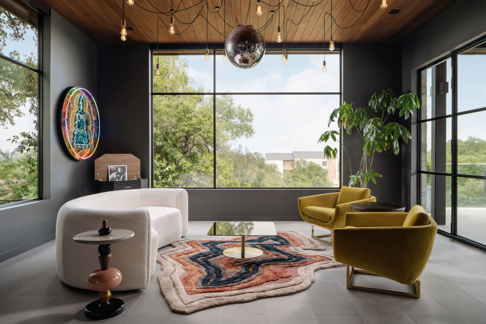 Sitting room with white couch, mustard-colored chairs, and a colorful rug