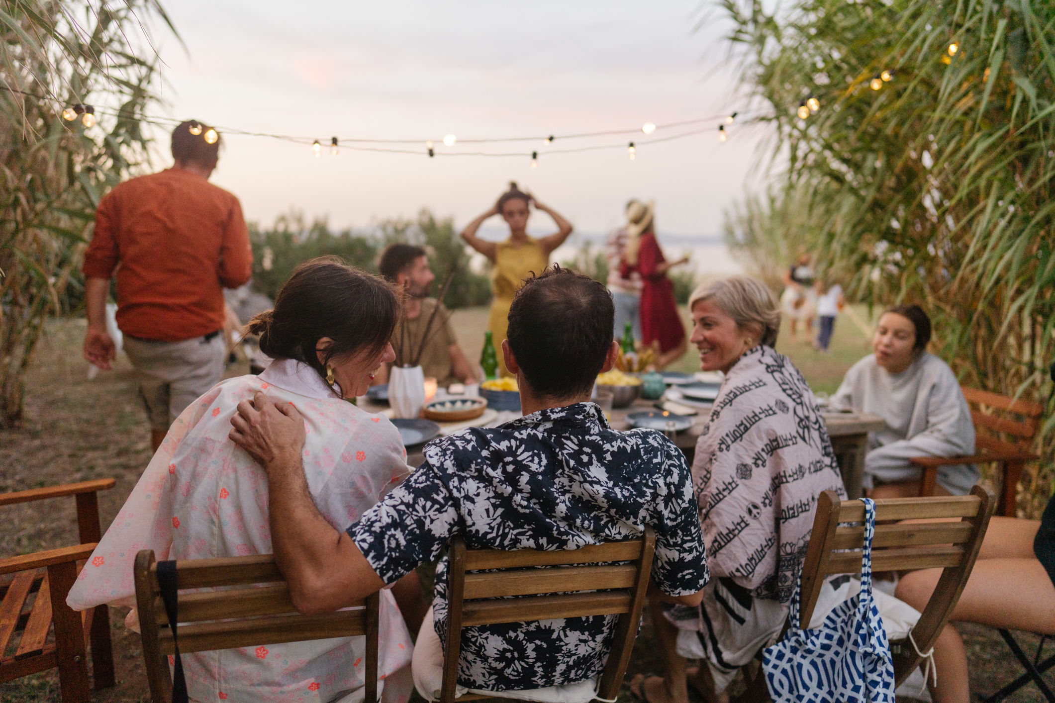 Photo of a big family enjoying the summer dinner party outdoors.