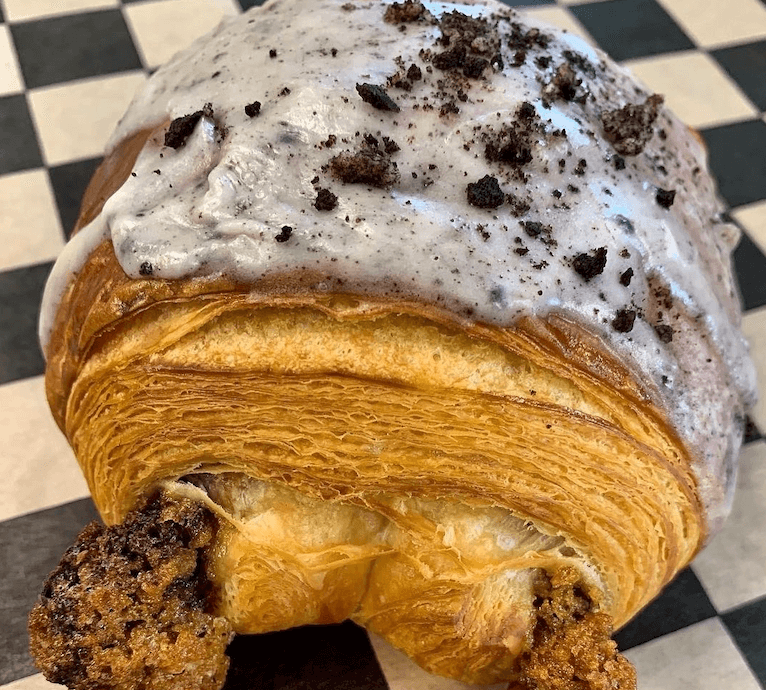 croissant with frosting on checkered waxpaper