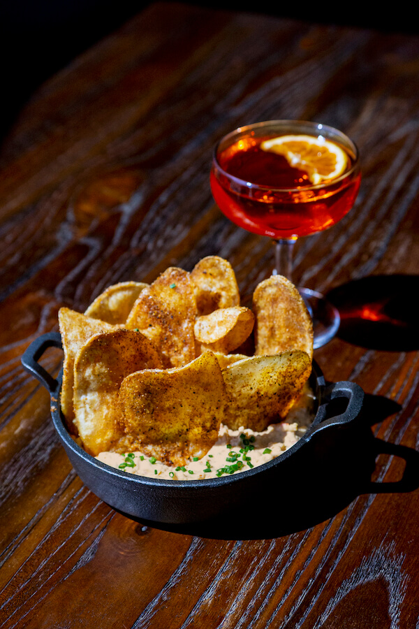 pimento cheese dip with chips and a brandy-based cocktail