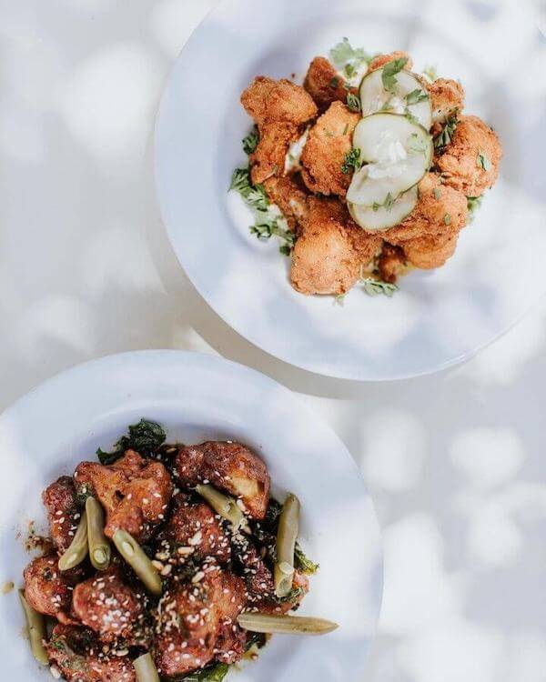 two veggie-based dishes in round white bowls