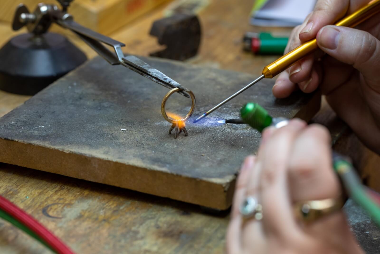 Close-up of person making a gold ring.