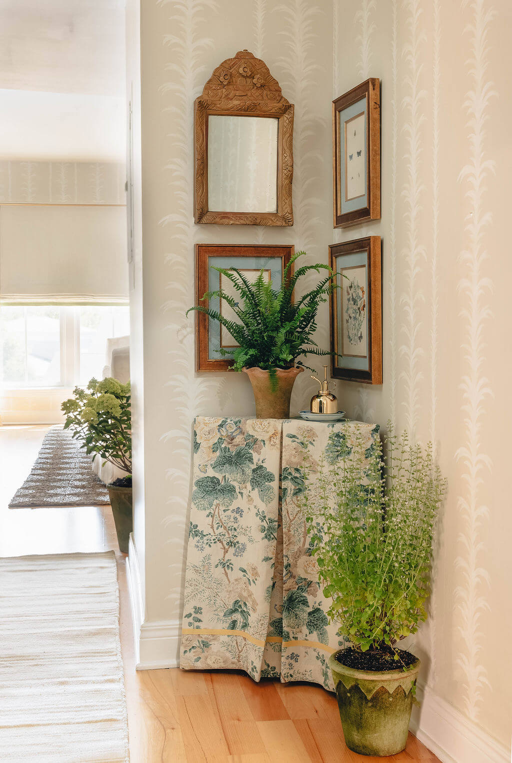 Corner with mirror, artwork, plant, and floral fabric stand