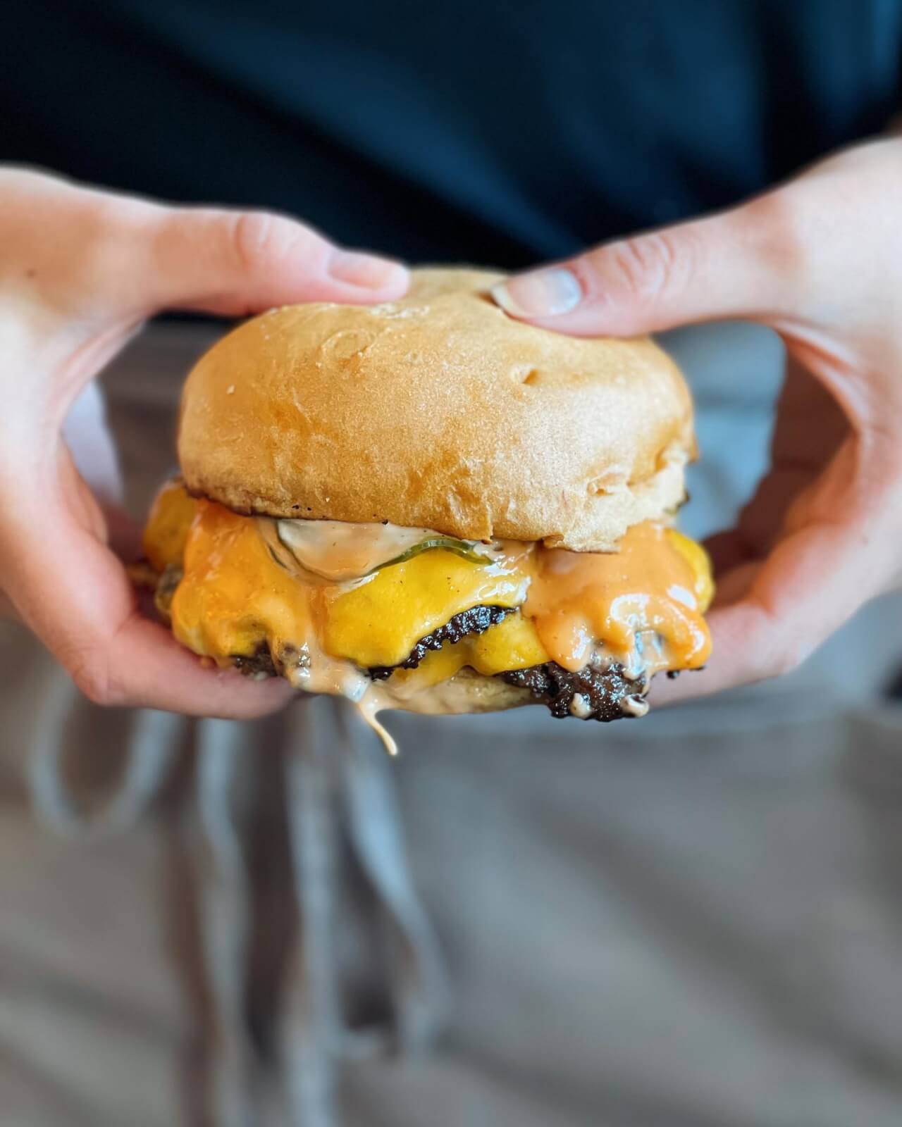 Person holding a cheeseburger
