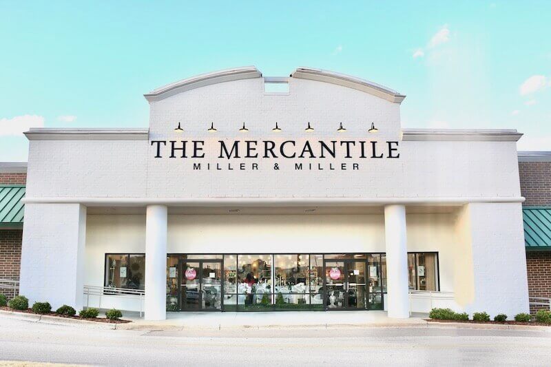 Front view of a building with the sign "The Mercantile Miller & Miller," known as one of the best gift stores in Birmingham. It features large windows and a welcoming double-door entrance.