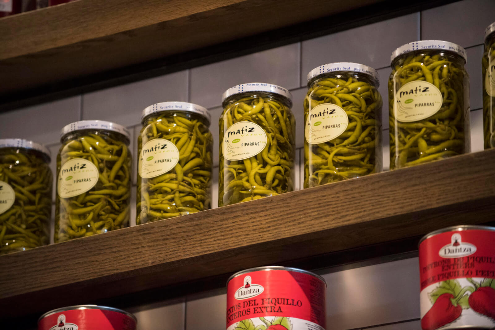 Lineup of glass jars with peppers.