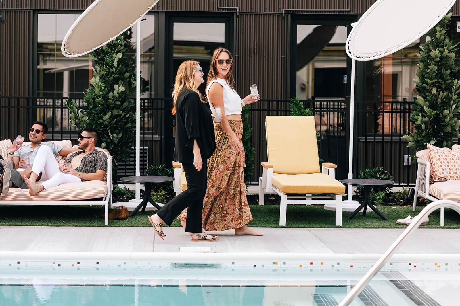 Two women walking by a hotel pool