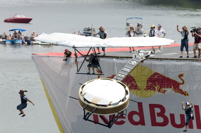 People jumping into water from tall structure.