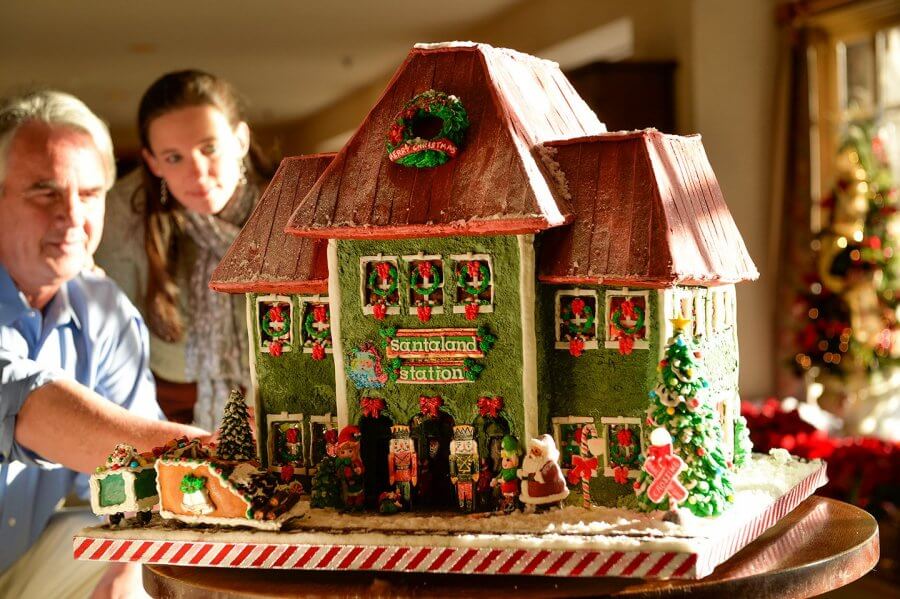 Man and woman look at large gingerbread house at Omni Grove Park Inn