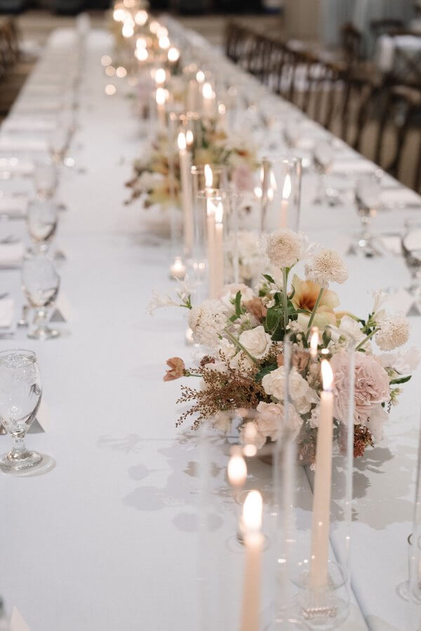 Long dining table with place setting and flower arrangements