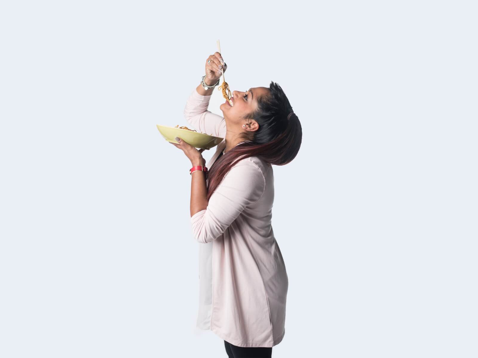 side view of a woman eating pasta