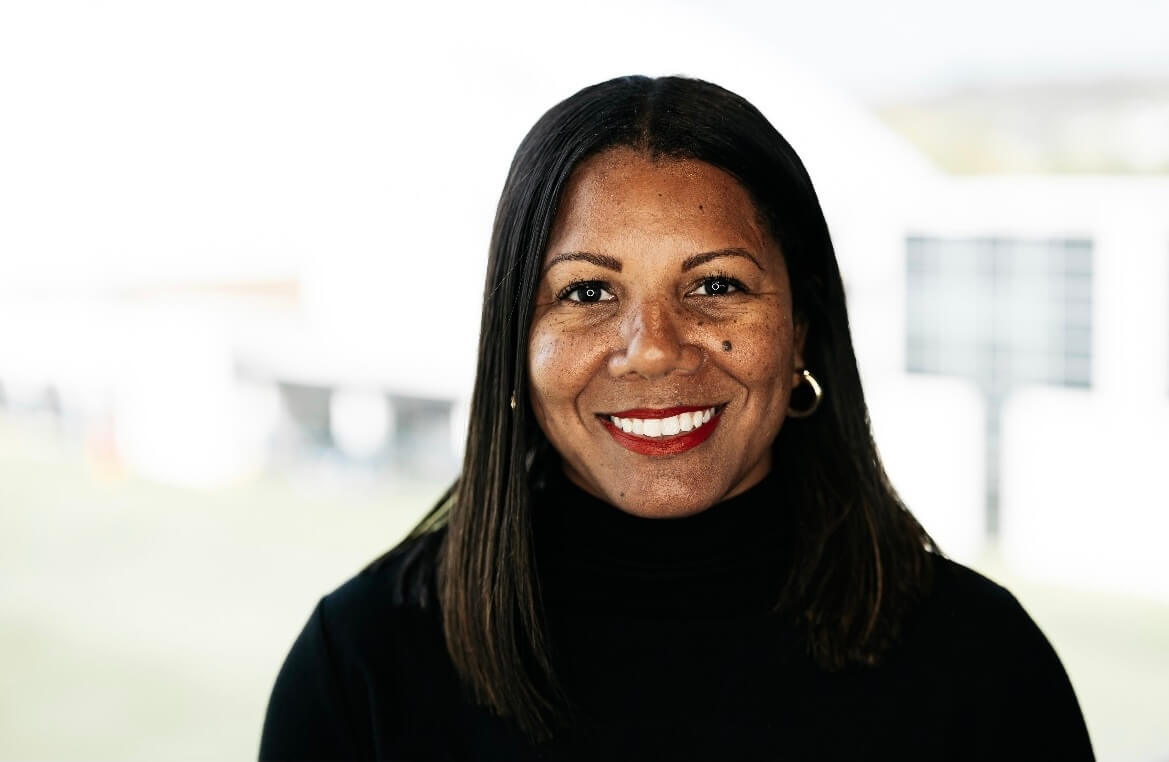 A woman in a black turtleneck, smiling