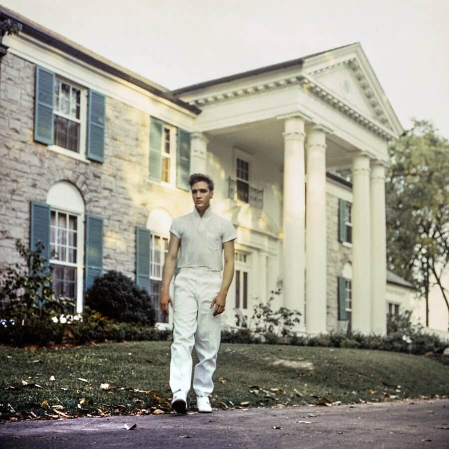 Elvis stands outside of Graceland