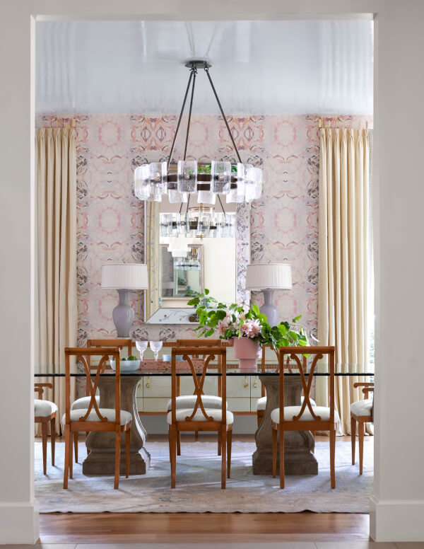 Dining room with glass table and fun pink wallpaper