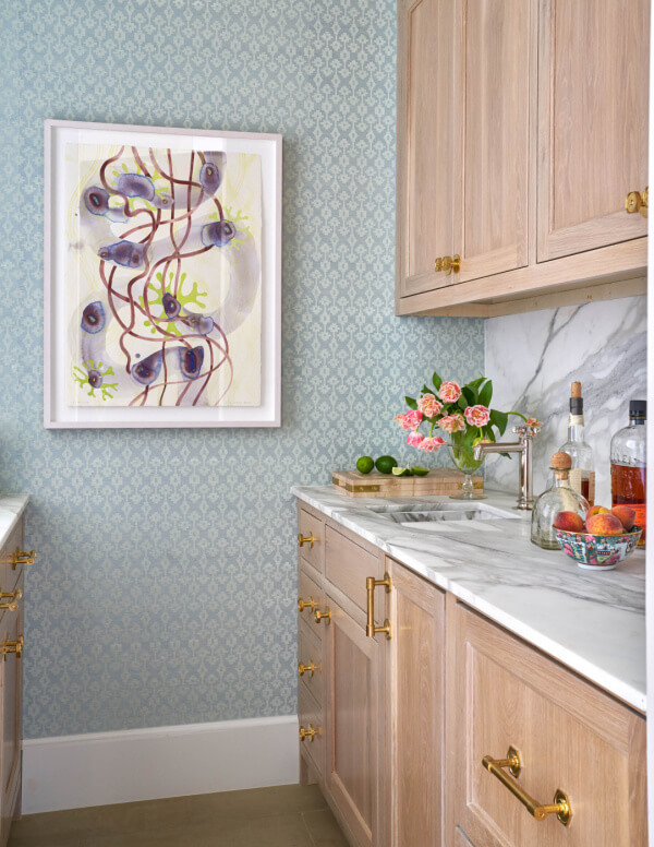 Butler's pantry with light wood cabinets and a marble backsplash