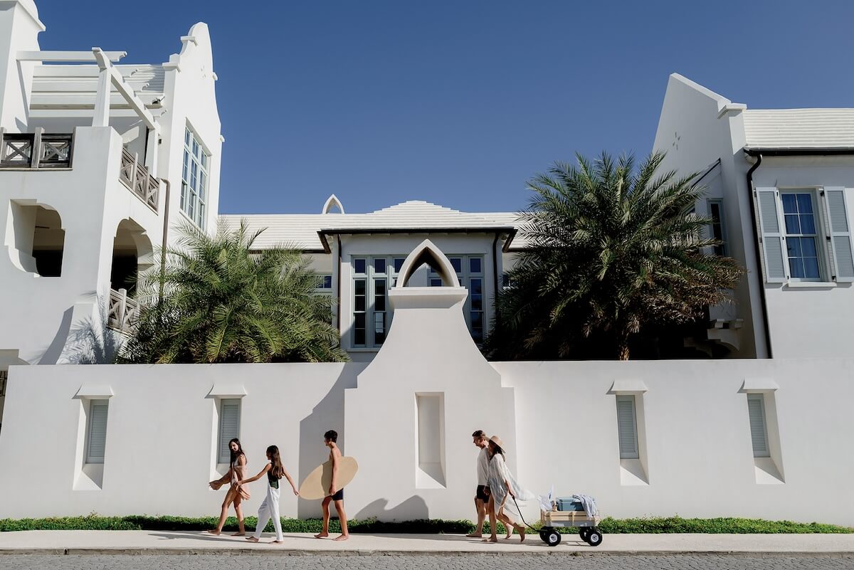 People walk near white houses in Alice Beach, Florida.
