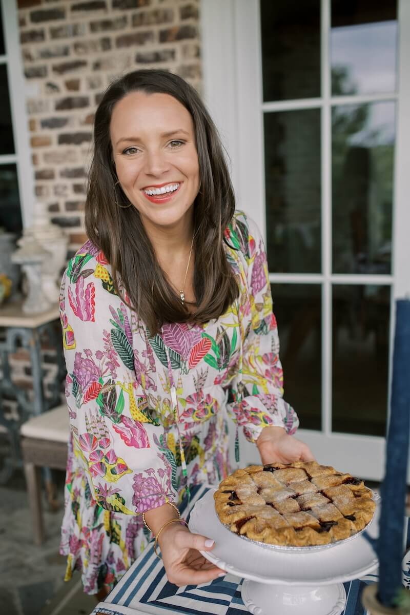 woman smiling and holding pie