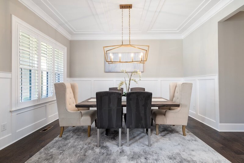 dining room with chairs and a rug and a chandelier
