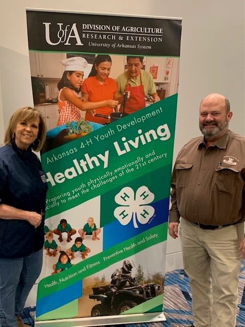 Cathy Pope posing next to 4-H sign