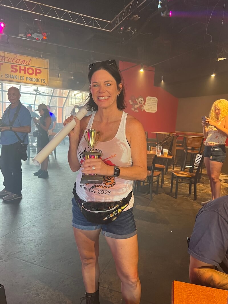 Jeannette posing with gold trophy in bar