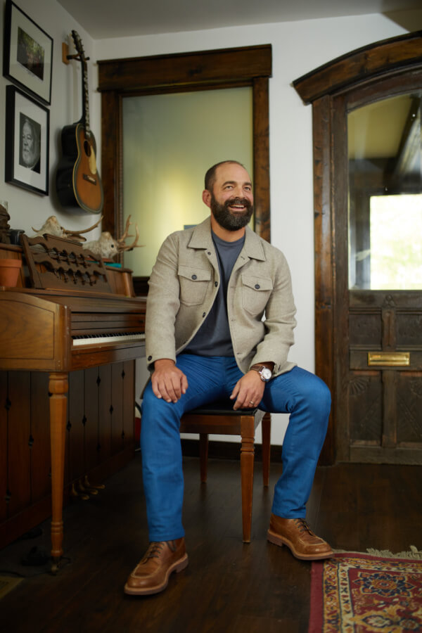 Drew Holcomb on a piano bench