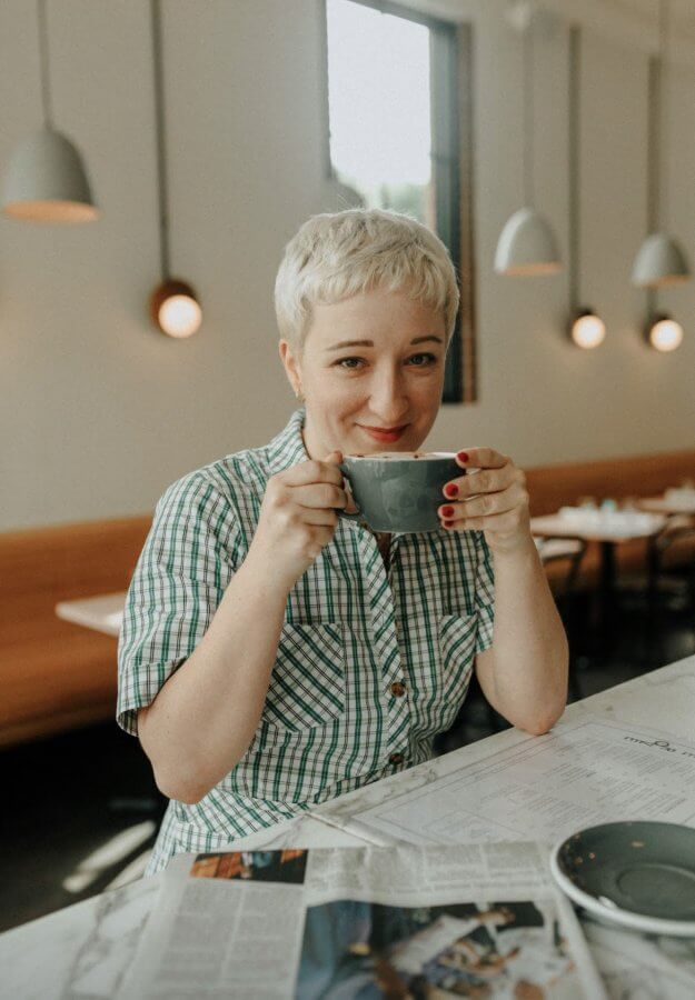 Hunter Claire Rogers sips coffee in a cafe