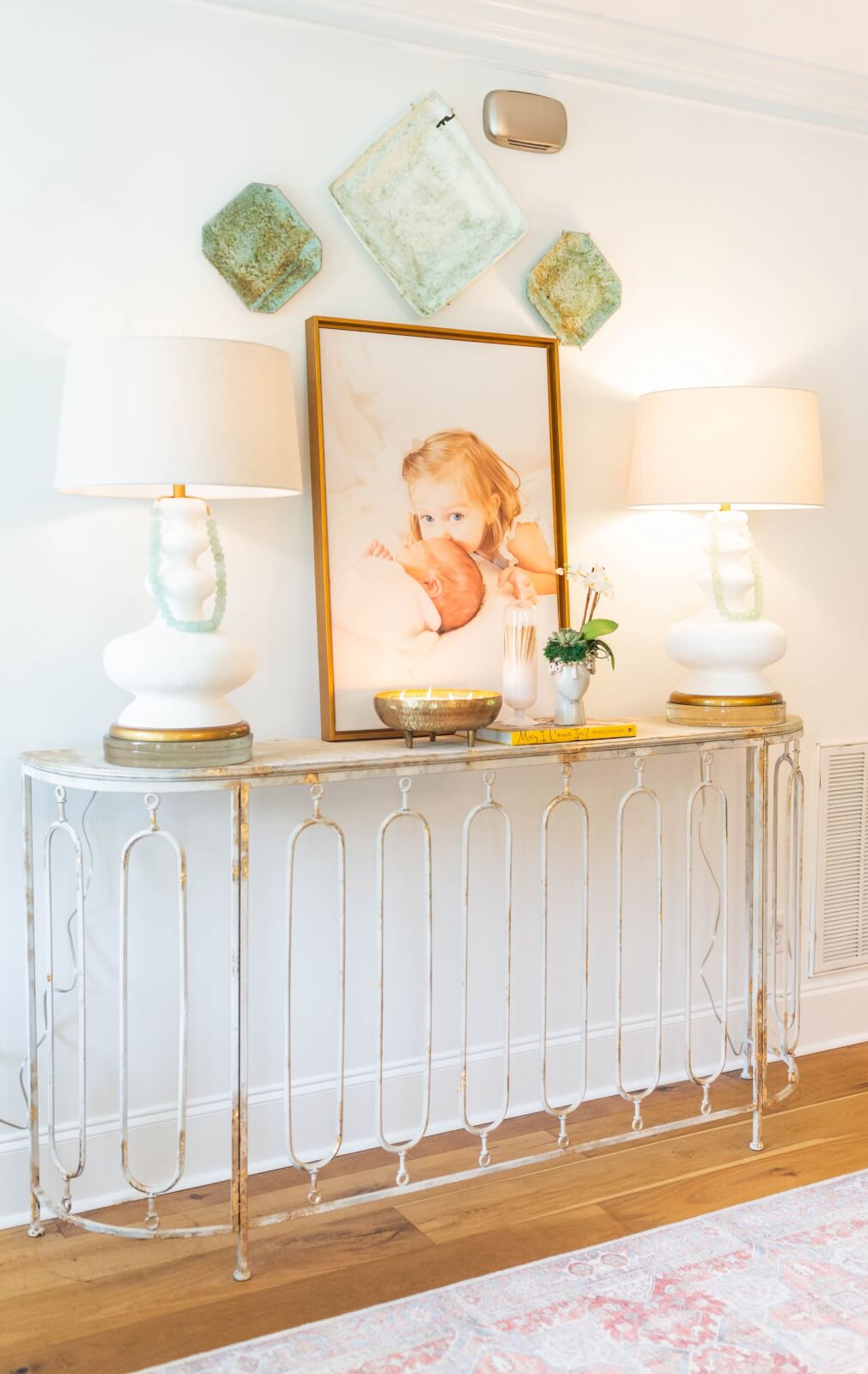 Entryway table with baby pictures and lamps