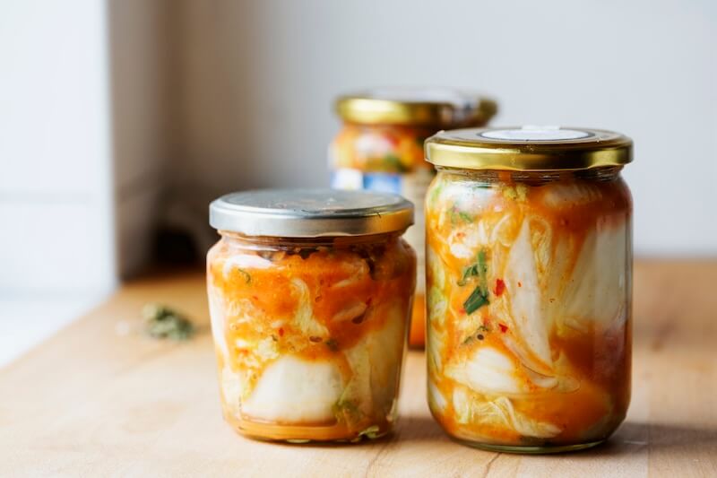 three jars of homemade kimchi on countertop