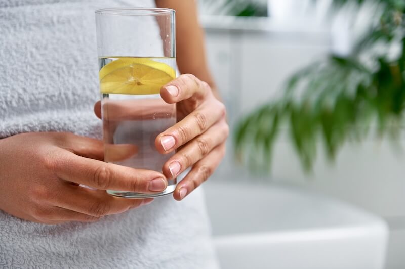 woman's hands holding lemon water