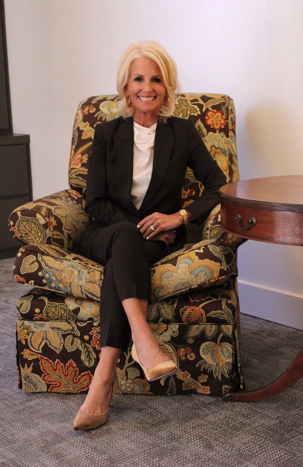 Blond woman sitting in a flowered chair